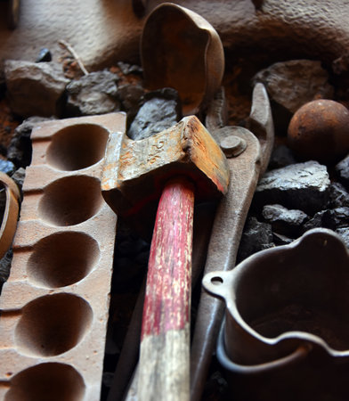 Two and a half pound mallot sits besides a mold for making mill balls.  One mill ball sits in photo...