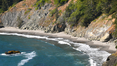 Small secluded bay has aqua blue water and gentle waves. Bay can be seen at the Arch Rock Viewpoint,...