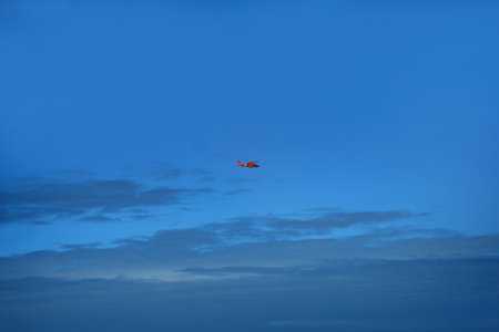 Red helicopter flies in blue skies.の写真素材