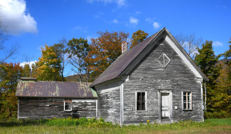 Old, rustic, tin roofed home has barn attached.  Paint is peeling and wooden structure is faded and...
