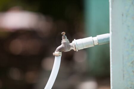 Old faucet with rubber hoseの写真素材