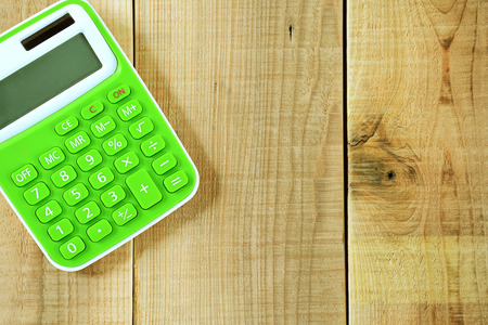 Green calculator on wooden background.の写真素材