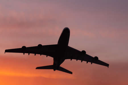 Black silhouette of plane on sunset backgroundの写真素材