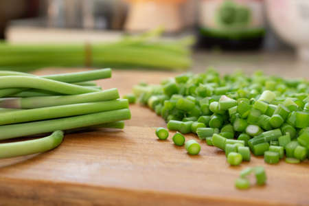 Cutting green garlic on tabletopの写真素材