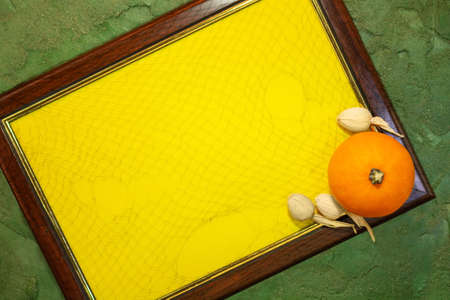 Frame with yellow paper blank space for text and pumpkin on  greenの写真素材