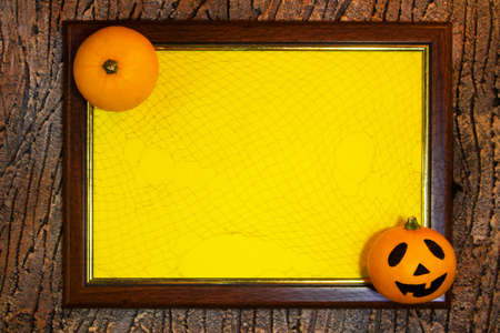 Halloween. Wooden frame with web, orange pumpkins and yellow paper blank space for text on tree bark. List for recording. Copy spaceの写真素材