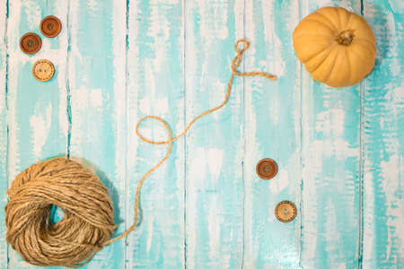 jute twine with buttons and pumpkin on a white-blue background. Copy spaceの写真素材
