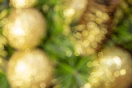 Abstract blurred shiny yellow Christmas balls and cone with barks and pine branches. New year card. Backgroundの写真素材