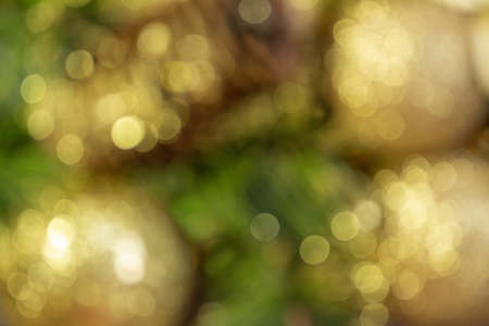 Abstract blurred shiny yellow Christmas balls and cone with barks and pine branches. New year card. Backgroundの写真素材