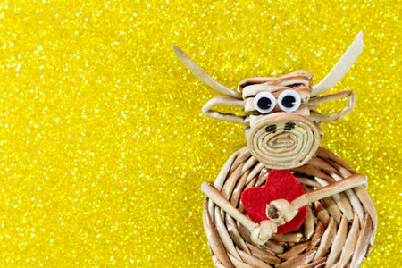 Ox with red heart on yellow background with sparkles. Christmas and New Year background. Symbol of year. Valentine's Day. Copy spaceの写真素材