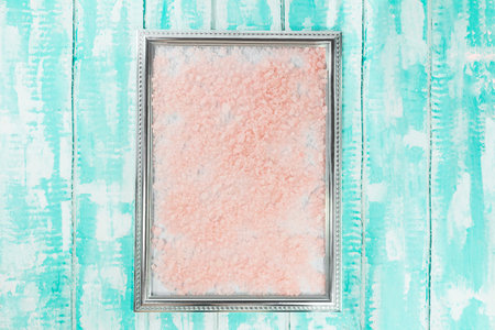 Frame with beige pink sea salt for text. On blue boards with whiteの写真素材