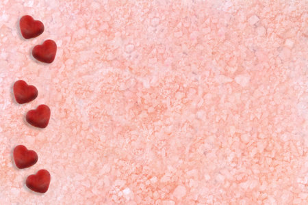 Beige pink background with little hearts. Sea salt. Texture. spa backdrop. St. Valentine day. Copy spaceの写真素材