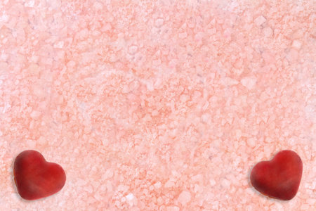 Beige pink background with two red hearts in the corners. Sea salt. Texture. spa backdrop. St. Valentine card. Copy spaceの写真素材