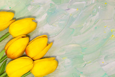 Yellow tulips on green background with brush strokes. Spring card. Women's day, Easter, birthday. Copy spaceの写真素材