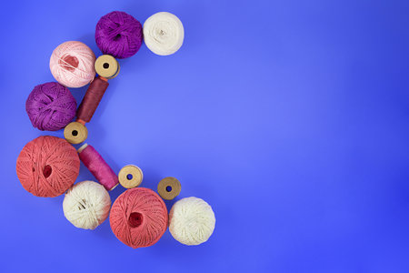 Crescent Moon Multicolored balls and bobbins of woolen yarn, sleeves of wooden thread on blue...