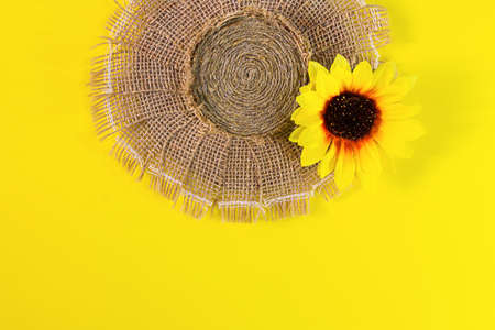Straw hat. Summer headwear from burlap and jute with a hearing on yellow background. Copy spaceの写真素材