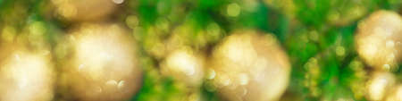 Blurred banner with Christmas tree and golden toys. Soft focus. New year background. Copy spaceの写真素材