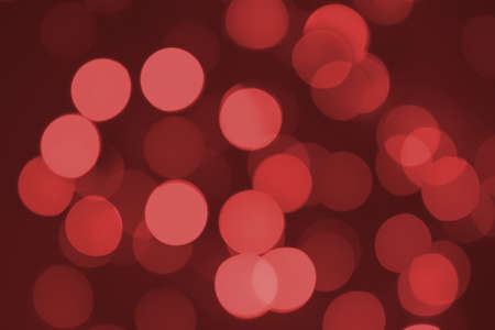 Defocused lights. Red bokeh on black background. Christmas and New year overlay. Copy spaceの写真素材