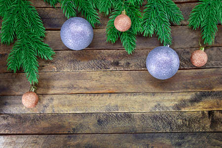 Silver and beige sparkling balls with glitter on wooden background with Christmas tree branches. New Year. Copy spaceの写真素材