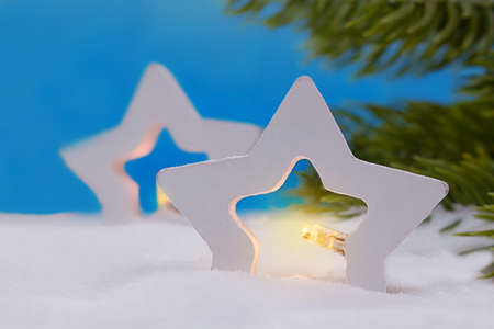 Two stars with lights in snow. Branches of Christmas tree. New Year. Copy spaceの写真素材