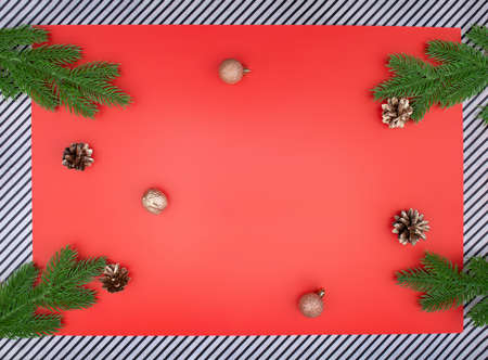 Spruce branches with golden cones and nuts with green spruce branches on red background and stripes. Christmas, New Year Copy spaceの写真素材