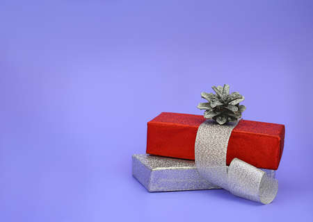 Gift shiny silver and red box with ribbon and pine cone. Christmas, New Year. Copy spaceの写真素材