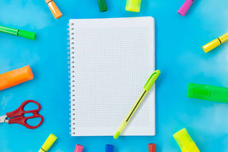 Felt tip pens, scissors and notepad for drawing or writing. Stationery on blue background. Concept back to school, education. copy spaceの写真素材