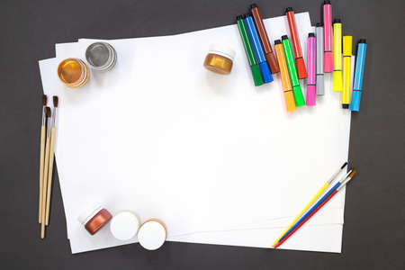 Paints, brushes, felt tip pens for drawing with white paper. Education concept, back to school. copy...