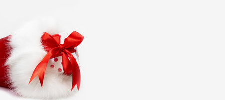 Gift wrapped with polka dots with red bow in bag with fur on white background. Banner. Christmas, New Year, sale. copy spaceの写真素材