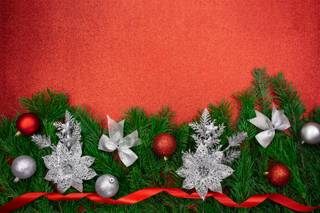 Shiny red, silver balls, sparkle flowers, bows and ribbons on fir branches from below on glitter background. Christmas, New Year. copy spaceの写真素材