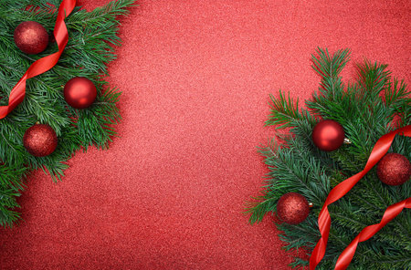 Shiny red balls and ribbons on fir branches on glitter background with place for text. Christmas, New Year. copy spaceの写真素材
