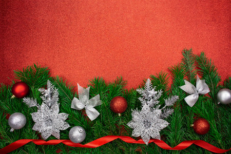 Shiny red, silver balls, sparkle flowers, bows and ribbons on fir branches from below on glitter background. Christmas, New Year. copy spaceの写真素材