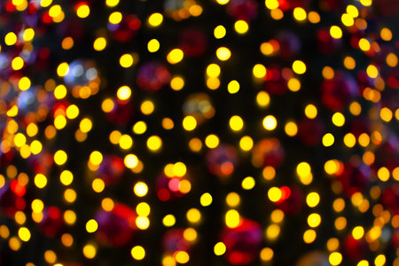 Blurred Christmas lamps on Christmas tree. Defocused yellow, red lights. copy spaceの写真素材