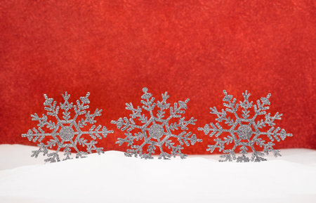 Shiny snowflakes on snow with red blurred background. Christmas, New Year. copy spaceの写真素材