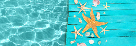 Starfish, shells on wooden blue boards of pier with water of sea. Vacation, travel, beach. Banner. copy spaceの写真素材