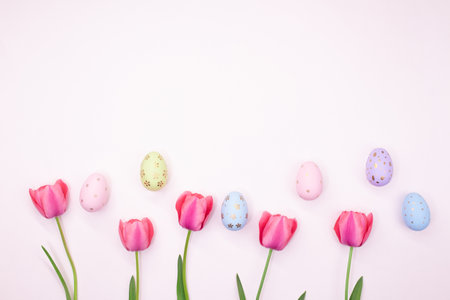 Pink tulips with painted eggs with place for text. Easter, spring. pastel background. copy spaceの写真素材