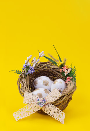 Easter, birthday poster with white golden eggs in nest with flower on yellow background. greetings vertical card. Promotion and shopping template. copy spaceの写真素材