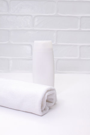 White bottle mockup with towel on table in bathroom. Cleanliness care. vertical. copy spaceの写真素材
