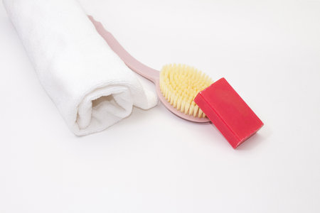 Rolled up towel with wash brush and pink soap on white isolated background. Cleanliness care. copy spaceの写真素材