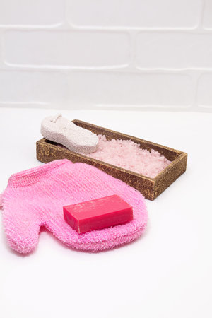 Washcloth, pumice for feet, soap, sea salt on white background. Concept of self care, bath, spa. vertical. copy spaceの写真素材
