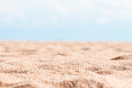 Beautiful beach with yellow sand with small pebbles, defocused blue sky in sunny day. panoramic view. Natural background for summer vacation. copy spaceの写真素材