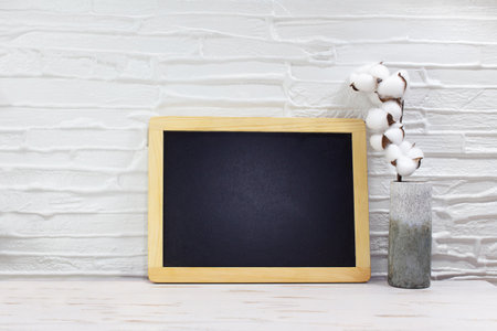 Black board for text, mock up next to vase with cotton on table. Front view empty. minimal concept. copy spaceの写真素材