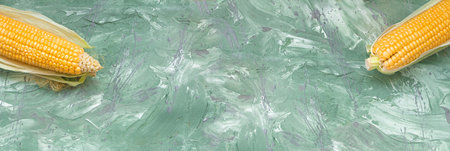 Yellow organic sweet corn on green marble malachite banner backgroundの写真素材