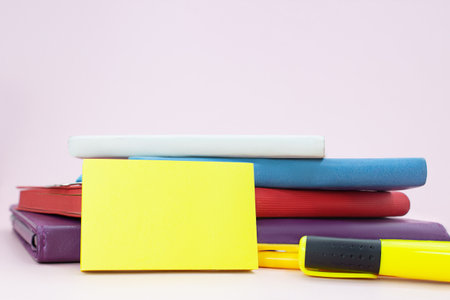 Stack of notepads with marker on pink table with sticky sticker. back to school. copy spaceの写真素材