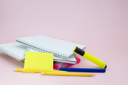 Notebooks with pens, markers and stickers on a pink background. Back to school business meeting. copy spaceの写真素材