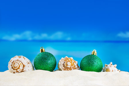 Shiny green balls with seashells on sand of beach. Christmas, New Year. Copy spaceShiny green balls with seashells on sand of beach. Christmas, New Year. Copy spaceの写真素材