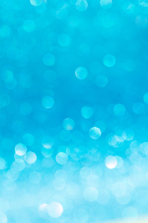 Moving blue shiny lights bokeh, defocused blue background with sparkle. Christmas, New Year, birthday, international women's day, holiday. Vertical. Copy spaceの写真素材