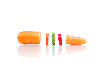 Cuted carrot with pieces of vegetables isolated on whiteの写真素材