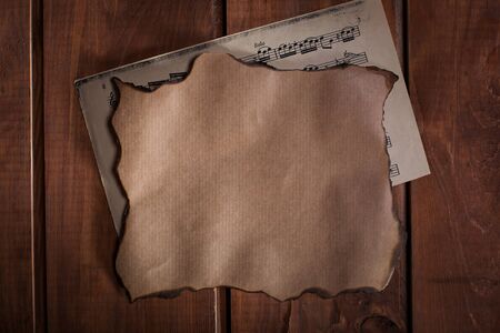 Old paper and a blanc with musical notes on wooden backgroundの写真素材