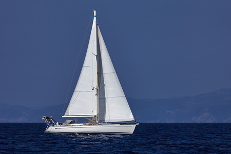 The white sails of yachts on the background of sea and sky